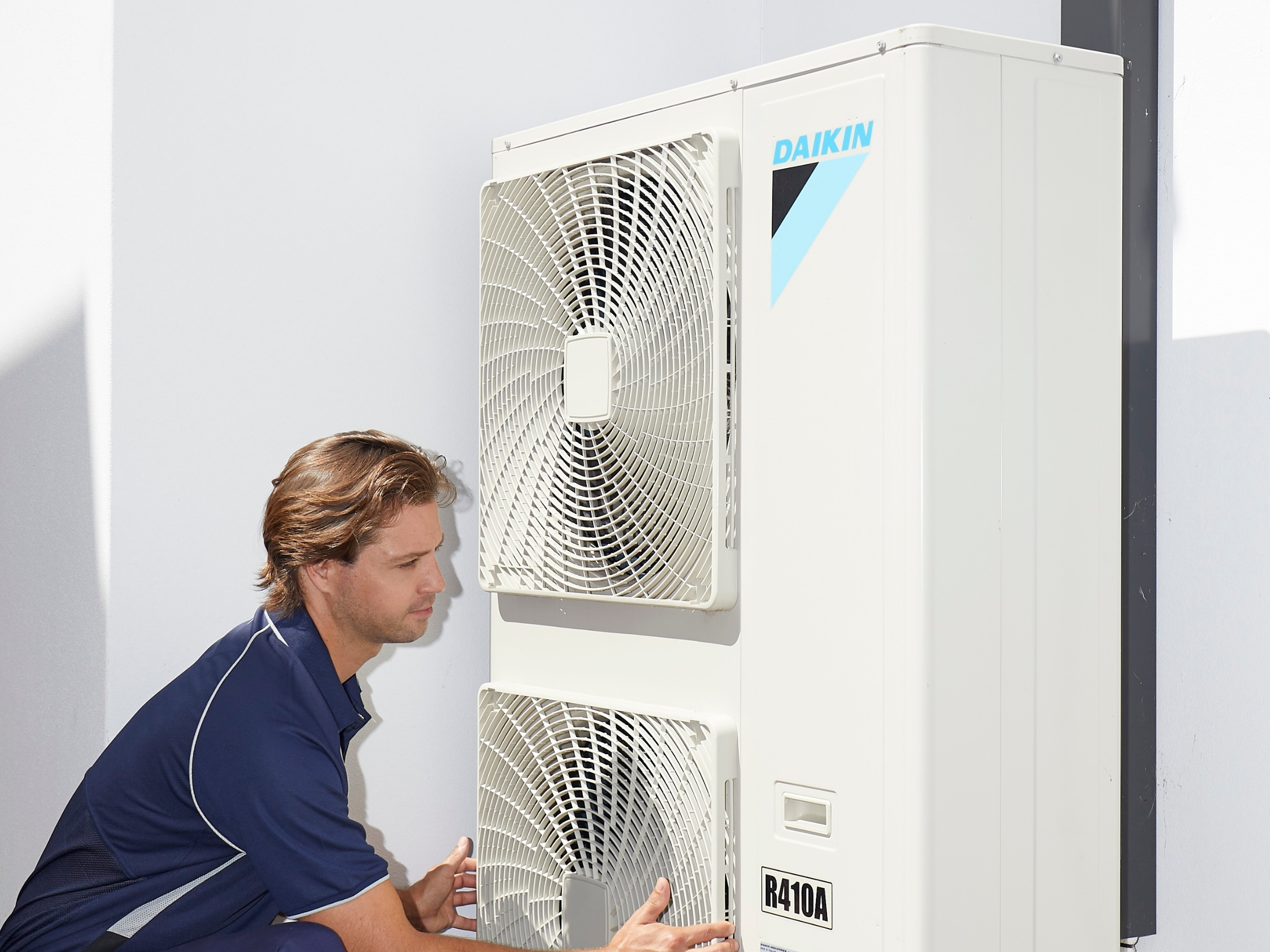 Technician adjusting Daikin indoor controls — Sunshine Coast